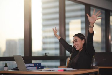 Siyah takım elbiseli Asyalı genç ve zeki iş kadını şehir ofisinde fazla mesai yapıyor..