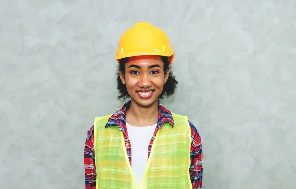 Portrait of professional young black woman civil engineer , architecture worker wearing hard hat safety for working in construction site or warehouse