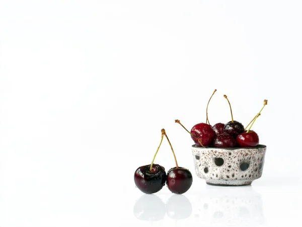 Třešně v misce na bílém pozadí — Stock fotografie