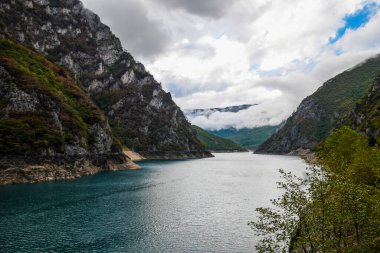 Piva Gölü 'nün manzarası, dağların arasında. Göl, Karadağ 'da suni bir tatlı su deposu haline geldi..