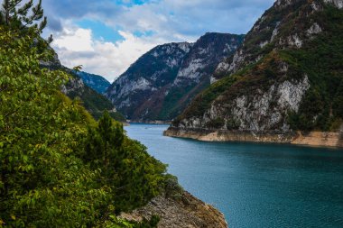 Piva Gölü 'nün manzarası, dağların arasında. Göl, Karadağ 'da suni bir tatlı su deposu haline geldi..