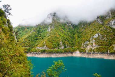 Piva Gölü 'nün manzarası, dağların arasında. Göl, Karadağ 'da suni bir tatlı su deposu haline geldi..