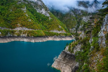 Piva Gölü 'nün manzarası, dağların arasında. Göl, Karadağ 'da suni bir tatlı su deposu haline geldi..