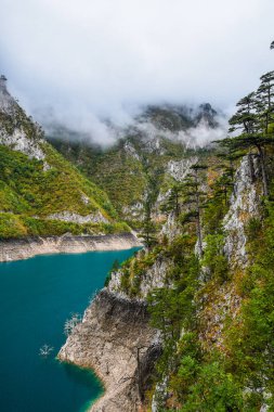 Piva Gölü 'nün manzarası, dağların arasında. Göl, Karadağ 'da suni bir tatlı su deposu haline geldi..