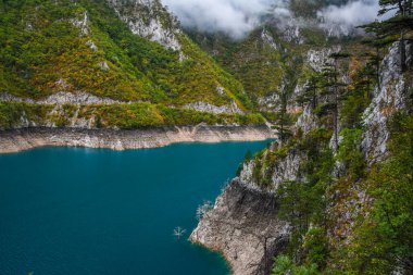 Piva Gölü 'nün manzarası, dağların arasında. Göl, Karadağ 'da suni bir tatlı su deposu haline geldi..