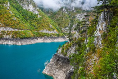 Piva Gölü 'nün manzarası, dağların arasında. Göl, Karadağ 'da suni bir tatlı su deposu haline geldi..