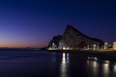 Gece boyunca Akdeniz 'deki Cebelitarık kayasına bakın La Linea de la Concepcion' dan.