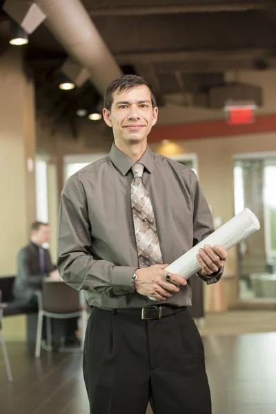 Manager holding blue prints in break room — Stock Photo, Image