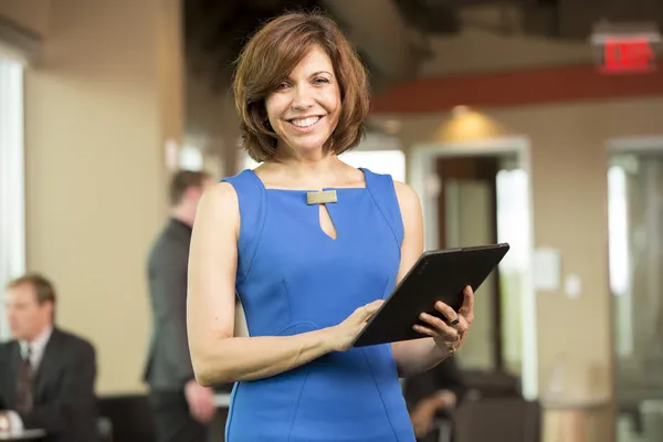 Hispanic business lady looking at tablet in the break room — Stock Photo, Image