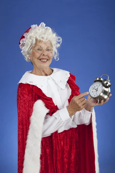 Mme Claus pointant du doigt une horloge qui montre presque minuit — Photo