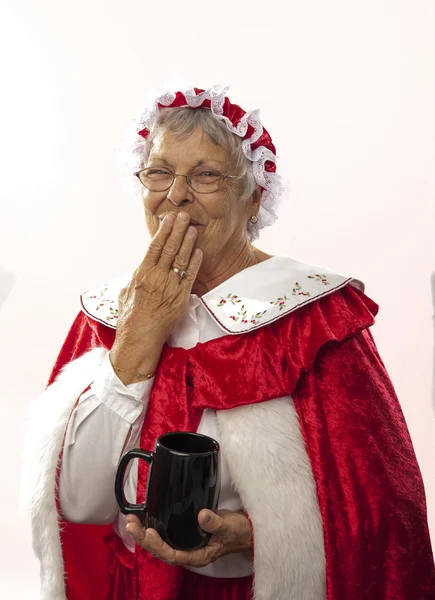 Mrs Claus isolata sul bianco, con in mano una tazza di cioccolata calda Fotografia Stock