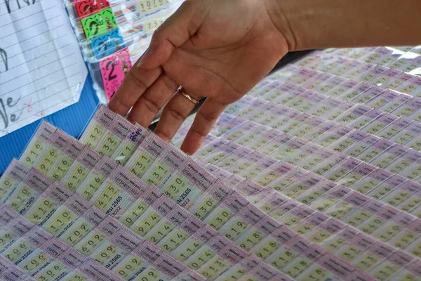 Gamblers are searching for Thai lottery numbers on the panel. Hope to win the big random prize.