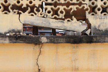 The cement fence was damaged to the point of a hole.