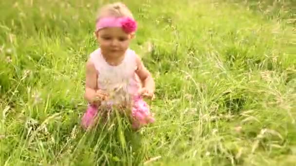 Bébé fille souriant tout en rampant sur l'herbe 