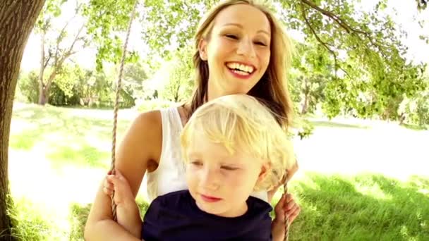 Familia alegre balanceándose en el parque — Vídeos de Stock