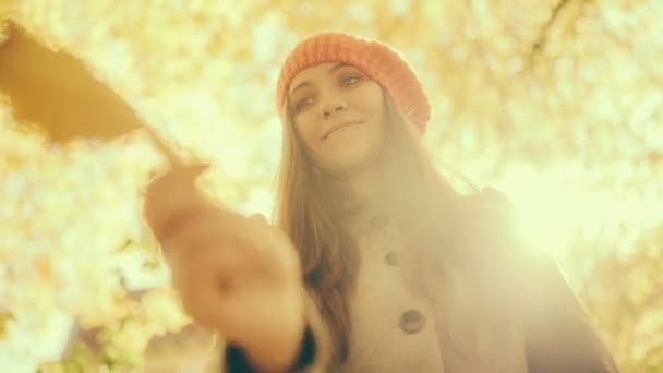 Mujer jugando con hojas de otoño y hojas que caen — Vídeos de Stock