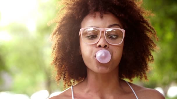 Africano americano chica soplando chicle — Vídeo de stock