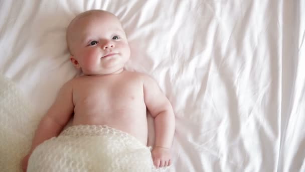 Babyjongen liggend in bed — Stockvideo