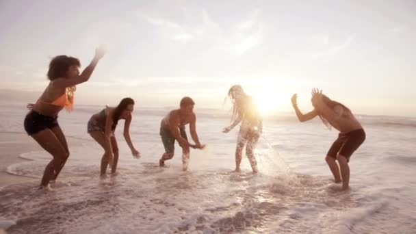Amigos salpicando agua en la playa — Vídeos de Stock