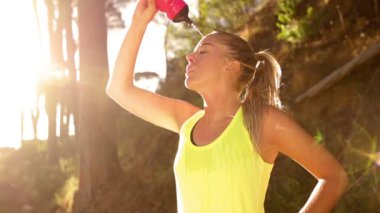 su kendi üzerine dökülen bir şişeden kadın