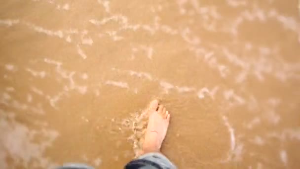 Man walking barefoot through waves — Stock Video