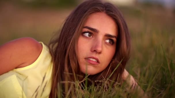 Серьезную девушку, лежащую в траве — стоковое видео