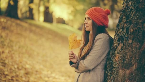 Jonge vrouw met blad in park spelen — Stockvideo