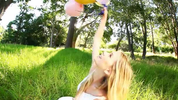 Frau lächelt, während sie Luftballons hält — Stockvideo