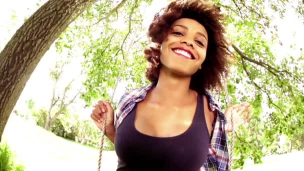 Rire jeune femme afro-américaine sur un swing — Video