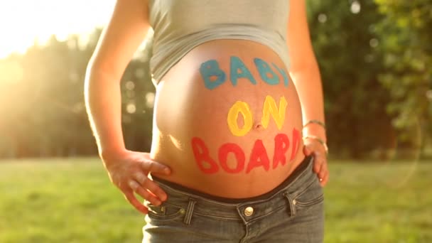 Gravid kvinna med "baby ombord", skriven på baby mage — Stockvideo