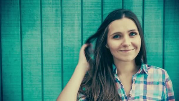 Woman leaning against blue wall — Stock Video