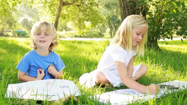 Мальчик и девочка рисуют в парке — стоковое видео