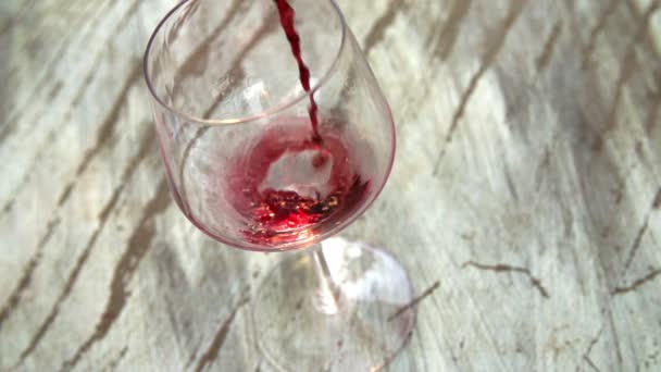 Versare il vino rosso in un bicchiere da vino — Video Stock