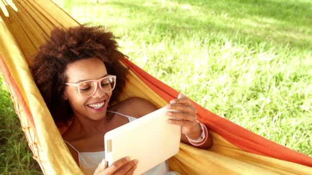 Femme dans un hamac regardant la tablette numérique — Video