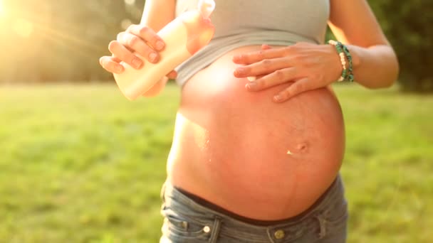 Mulher grávida colocando loção na barriga do bebê — Vídeo de Stock