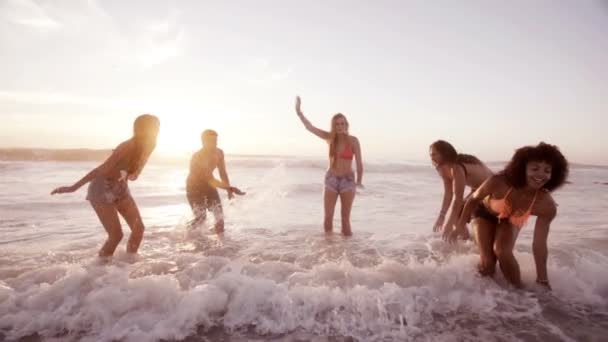 Freunde planschen Wasser am Strand — Stockvideo