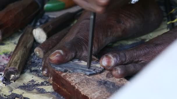 African carver creating a souvenir for tourists — Stock Video