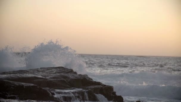 Волны брызгают по камням — стоковое видео