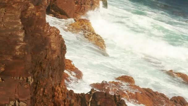 Vagues écrasant et roulant sur les rochers à la côte 