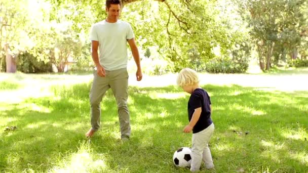 Отец и сын играют в футбол — стоковое видео