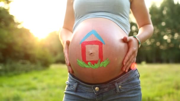 Barriga de bebê à luz do sol com casa pintada nele — Vídeo de Stock