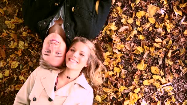 Couple is lying on the autumn leaves — Stock Video