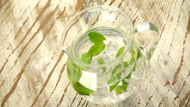 Jug of water with fresh mint leaves — Stock Video