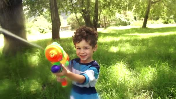 Boy playing with squirt gun — Stock Video