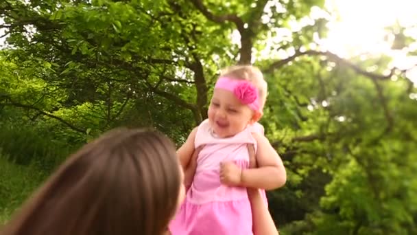 Дитяча дівчинка піднята в повільному русі матір'ю — стокове відео