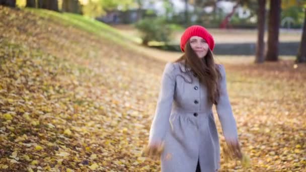 Jonge vrouw met blad in park spelen — Stockvideo