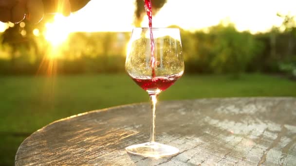 Rotwein in ein Weinglas gießen