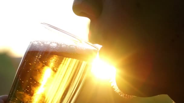 Человек пьет пиво в солнечный день — стоковое видео