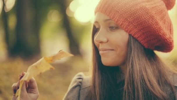 Fille en automne jouer avec la feuille dans le parc 
