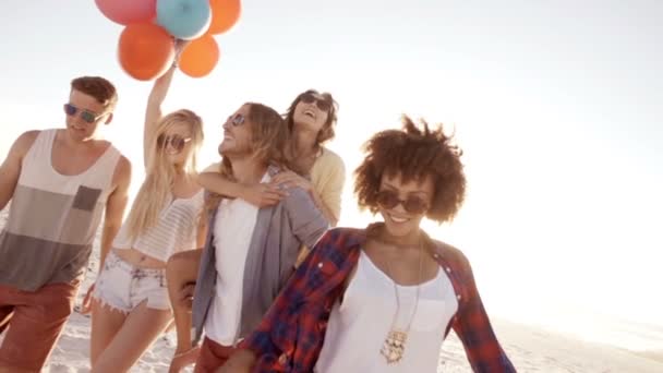 Друзья играют с воздушными шарами на пляже — стоковое видео